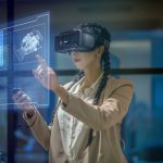 Female engineer wearing a virtual reality headset at work to explore an upcoming mechanical engineering project. She uses her hands to manipulate and explore the finer details.